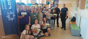 uczniowie z policjantami na wspólnym zdjęciu na korytarzu szkolnym