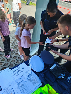 policjanci odbijają odciski paluszków dzieci