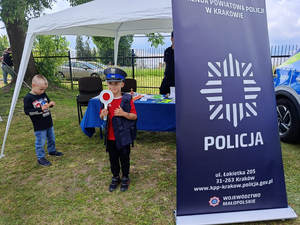dziecko w policyjnej czapce i kazmizelce z policyjną tarczą