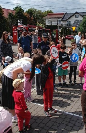 policjantka a przed nią dzieci i rodzice na pikniku
