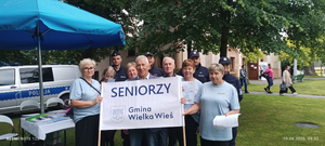 policjanci i seniorzy na wspólnym zdjęciu trzymają transparent z napisem seniorzy wielka wieś