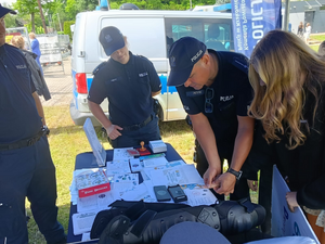 policjant odbija uczennicy odciski palców pod policyjnym namiotem