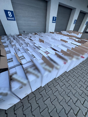 kartony z zawartością papierosów leżą przed garażami