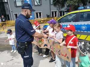 policjant razem z dziećmi na tle radiowozu