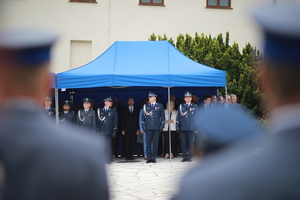 policjanci i osoby cywilne nauroczystym apelu stojący pod namiotem koloru niebieskiego