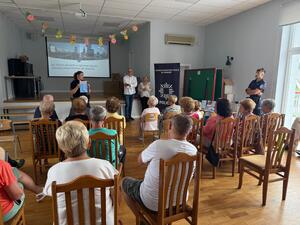 policjantka w mundurze podczas prelekcji przed nią siedzą seniorzy