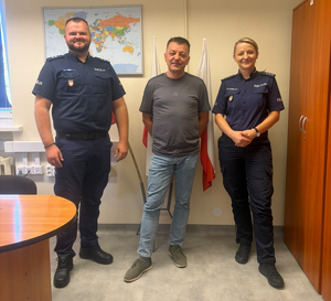 policjantka i policjant w mundurach pomiędzy nimi stoi mężczyzna po cywilnemu