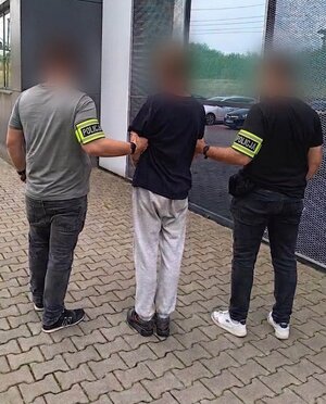 policjanci bez munduru prowadzą zatrzymanego mężczyznę