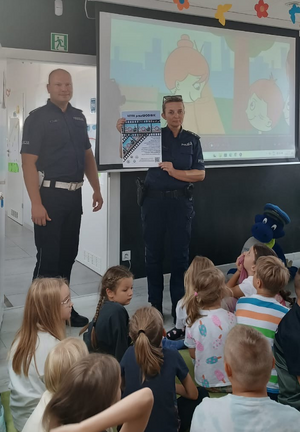 policjantka i policjant podczas prelekcji w sali przed nimi siedzą dzieci