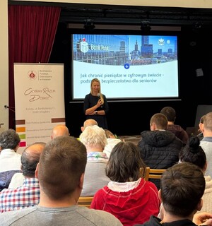 kobieta po cywilnemu prowadząca wykład dla seniorów za nią wyświetlona prezentacja PKO banku polskiego