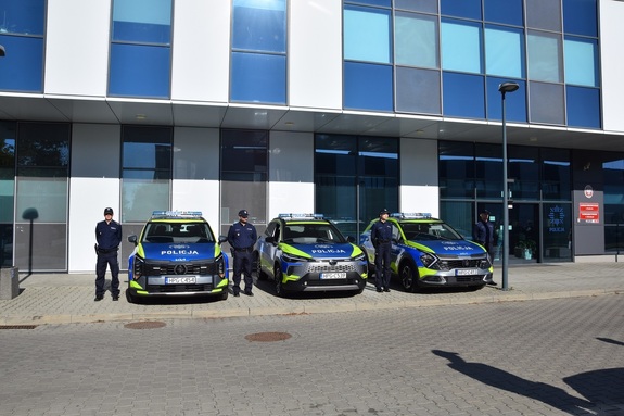 budynek komnedy a przed nim trzy oznakowane radiowozy i policjanci stojący obok samochodów