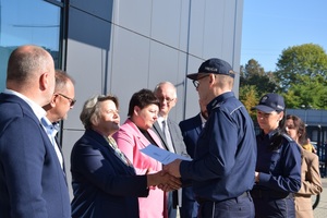 policjant w mundurze wręcza podziękowania samorządowcom