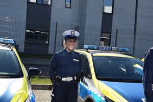 policjantka w mundurze stoi obok radiowozu