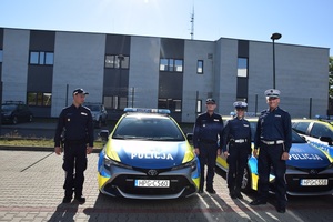 umundurowani policjanci stoją obok radiowozów
