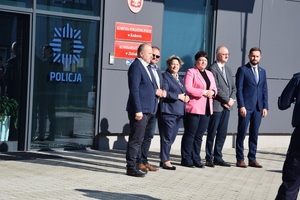 zaproszeni goście stoją w rzędzie przed budynkiem komendy