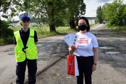 policjantka i pracownica PKP stojące przodem z rozlozonymi ulotkami w ręku