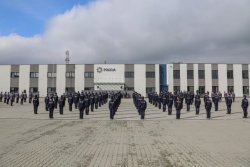 szereg policjantów stojących tyłem podczas roty ślubowania