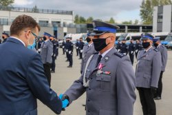 wojewoda podający rękę policjantowi który otrzymał odznaczenie