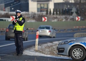 policjant mierzący fotoradarem w nadjeżdżające pojazdy