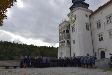 policjanci i zaproszeni goście stojący na placu zamku w pieskowej skale- ustawieni do grupowego zdjęcia