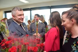 przewodniczący związków zawodowych policjantów woj. małopolskiego wręczający kwiaty policjantce