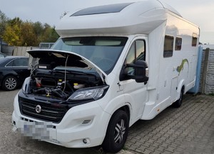 camper z otwartą maską na parekjingu