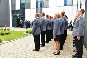 awansowani policjanci stojący w szeregu stojący bokiem do zdjęcia