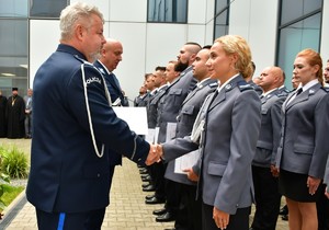 zastępca komendanta wojewódzkiego podający rękę awansowanej policjantce stojącej w szeregu