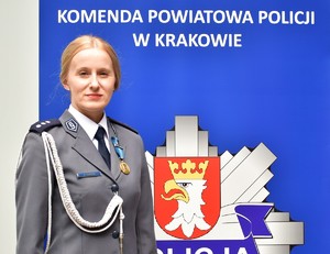 policjantka na tle baneru KPP w Krakowie