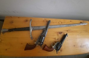 dwa pistolety i miecz leżące na biurku (2)