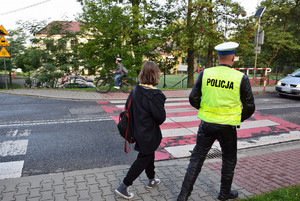 policjant wchodzący na pasy z uczennicą