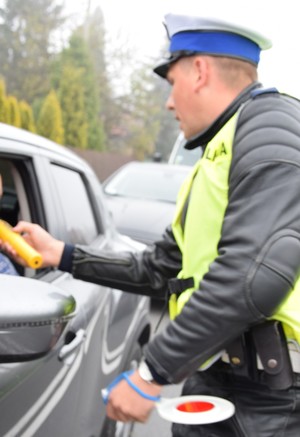 policjant ruchu drogowego badający trzeźwość kierującego