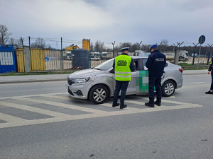 policjant i funckjionariusz ITD kontrolują pojazd, z przodu pojazd ITD a za kontrolowanym pojazdem radiowóz