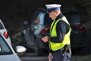 Policjant ruchu drogowego wykonujący przejeżdżającym kierującym szybkie ...