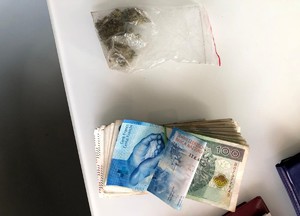 marihuana w worku strunowym obok duży plik banknotów