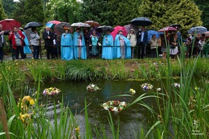 uczestnicy pikniku stojący przy rzecze podczas puszczania wianków