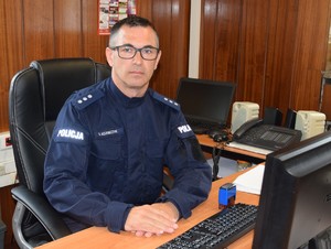 siedzący za biurkiem zastępca komendanta komisariatu w Zabierzowie
