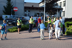 policjanci i straż gminna przy przejsciu dla pieszych przy szkole rozdaje odblaski