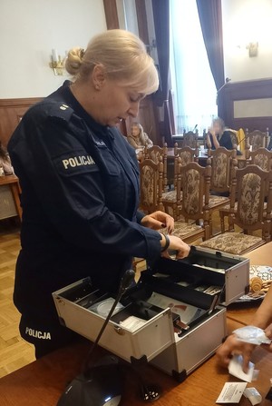 policjantka otwierajaca walizkę edukacyjną z imitacją dopalaczy (2)