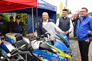 policyjne stoisku, przy nim minister, wicemarszałek i starostwa, w tle policjantki, na pierwszym planie motor