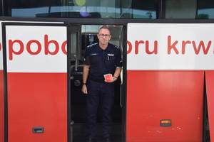 umundurowany policjant wychodzący z krwiobusa po oddanbiu krwi